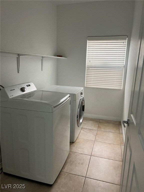 Laundry area featuring baseboards, light tile patt