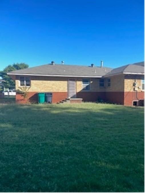 Rear view of house featuring a yard