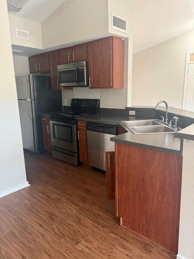 Kitchen with stainless steel appliances, dark cou