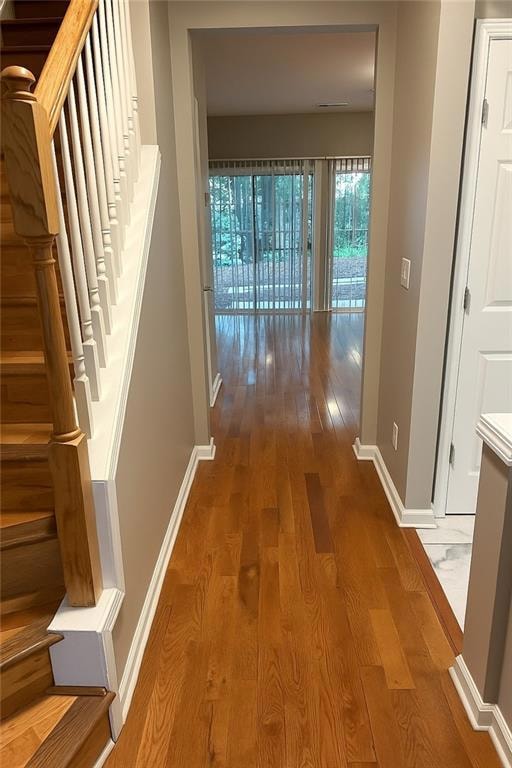 Corridor featuring wood finished floors and stairs