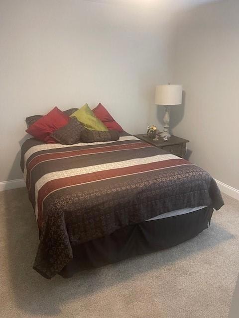 Carpeted bedroom featuring baseboards