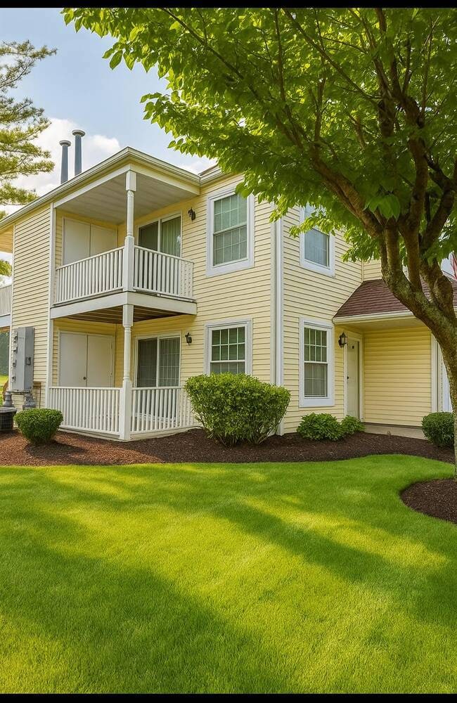 View of front of house featuring a balcony and a front yard