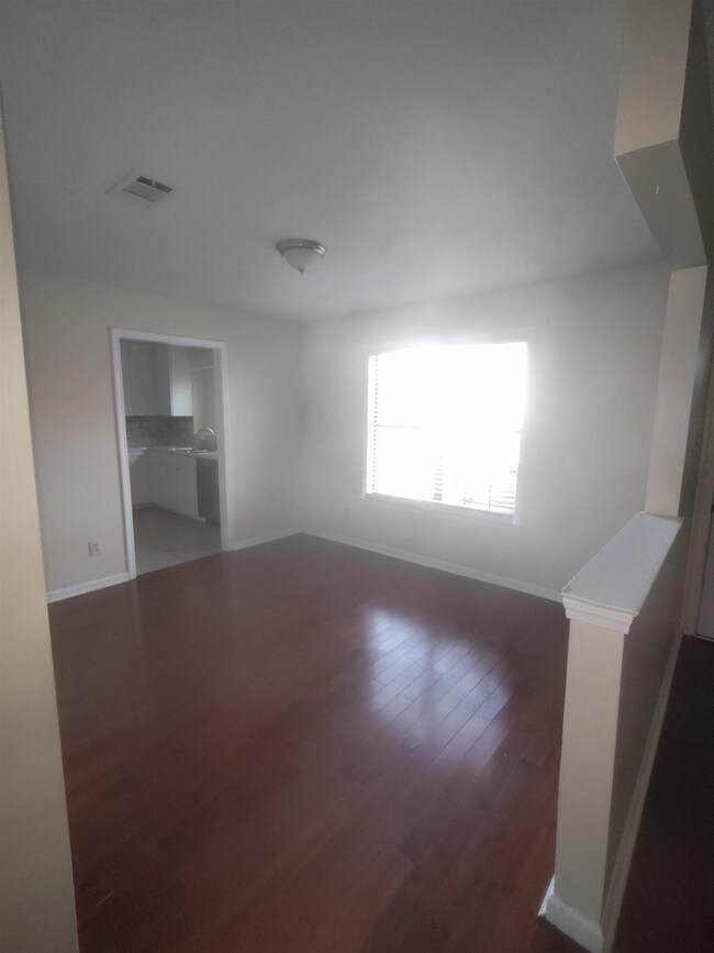 Empty room with wood finished floors, visible vent
