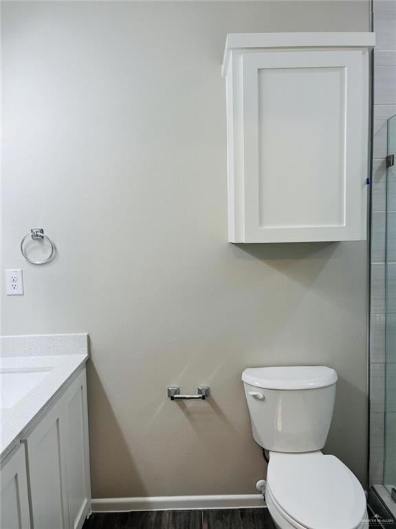 Bathroom featuring vanity, dark wood-style flooring, and a shower stall