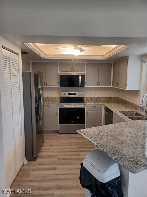 Kitchen featuring a tray ceiling, stainless steel