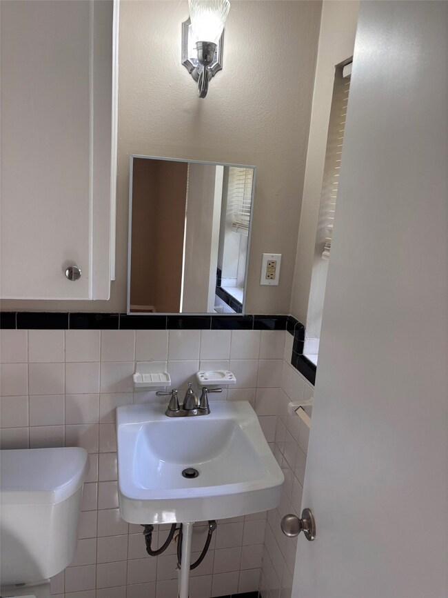 Bathroom featuring tile walls and a sink