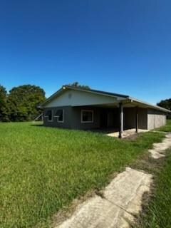 View of home's exterior featuring a lawn, driveway, and a garage