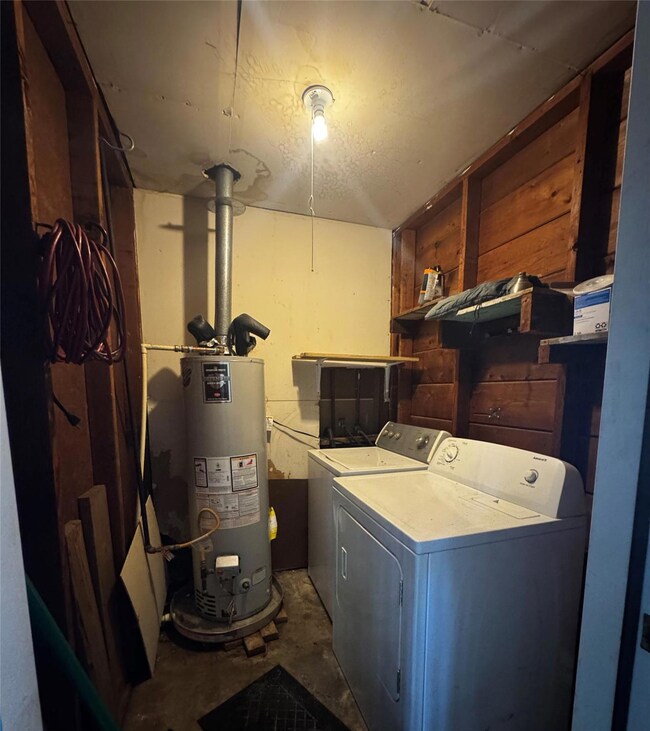 Washroom with water heater and washer and clothes