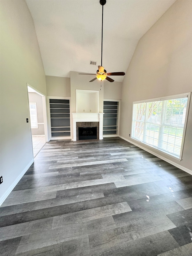 Unfurnished living room with high vaulted ceiling,