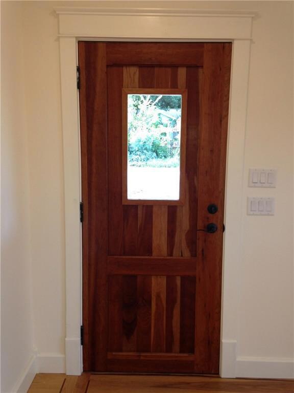 Doorway to outside featuring baseboards and wood 