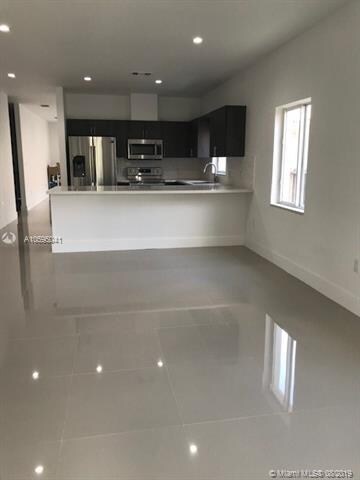 VIEW OF KITCHEN AND FAMILY ROOM FROM BACK DOOR