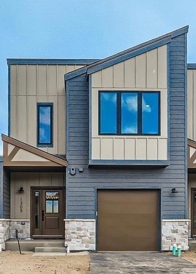 Contemporary house with stone siding, board and ba