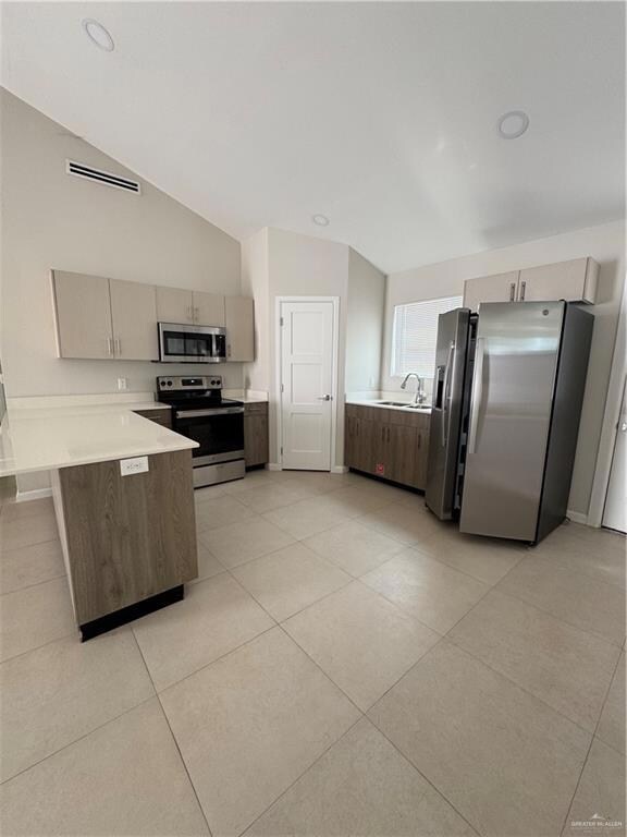 Kitchen featuring stove, light countertops, a sink, a peninsula, and fridge