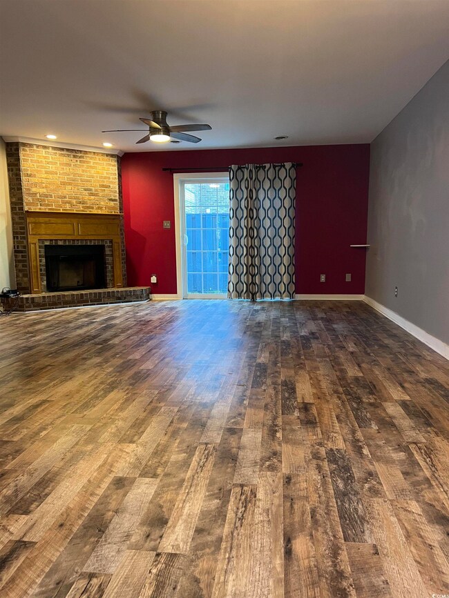 Unfurnished living room featuring wood-type floori