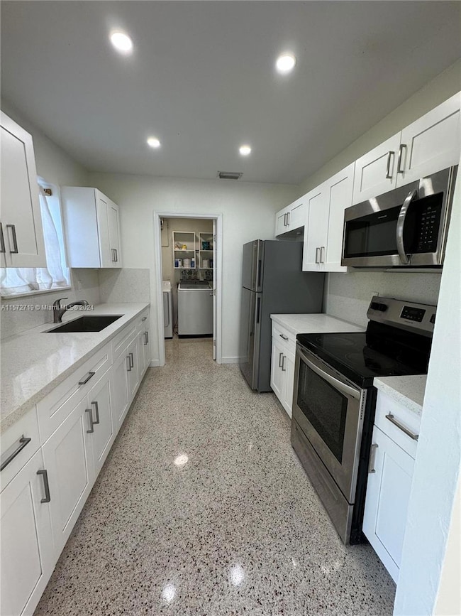 View of Kitchen and Laundry room where you find washer, dryer, electrical box and A/C Unit
