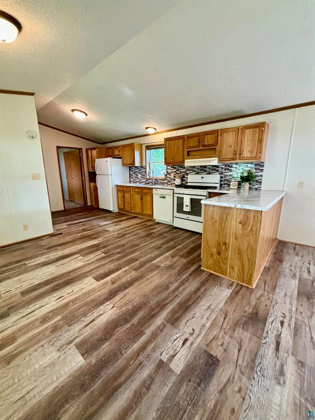 Kitchen featuring white appliances, a textured cei