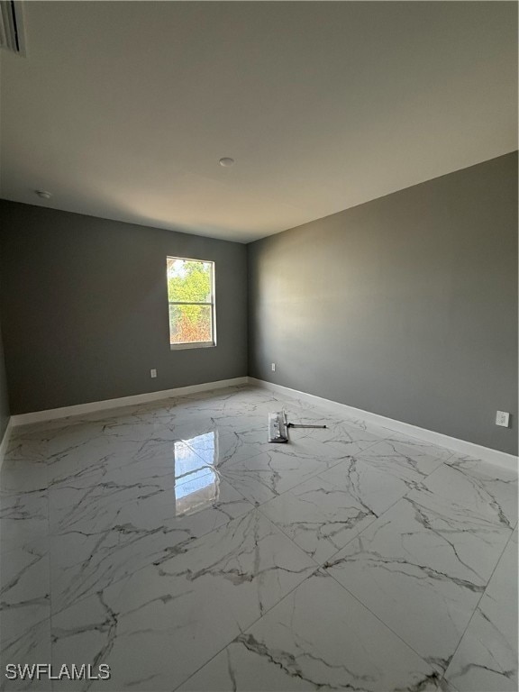 Unfurnished room with baseboards and light marble
