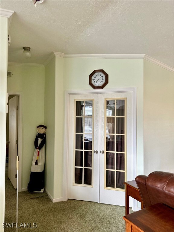 Doorway featuring crown molding, carpet, a texture