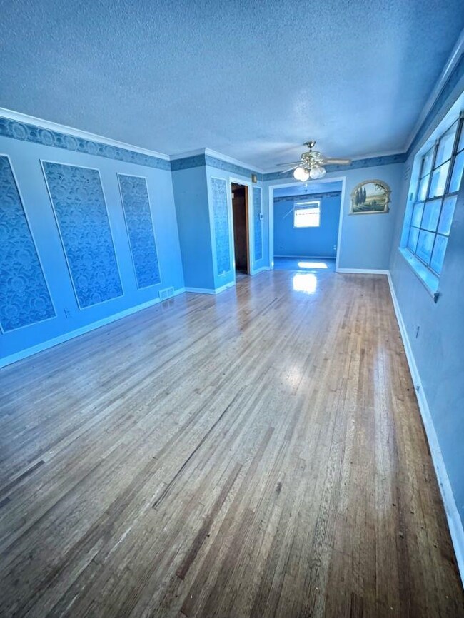 Unfurnished living room with ceiling fan, hardwood