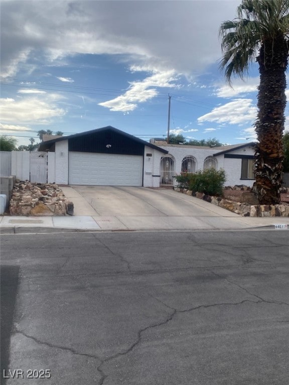 Single story home featuring a garage and concrete