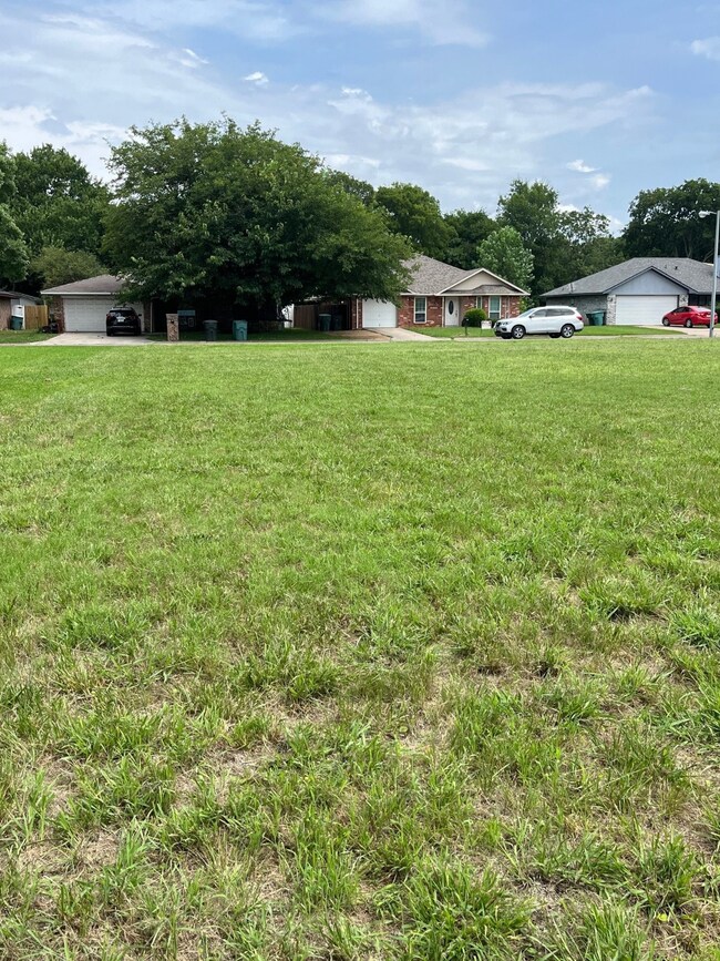 View of green lawn featuring a garage