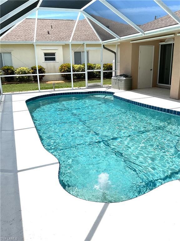Outdoor pool with a patio and glass enclosure