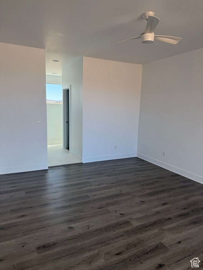 Spare room with dark wood-style floors and a ceiling fan