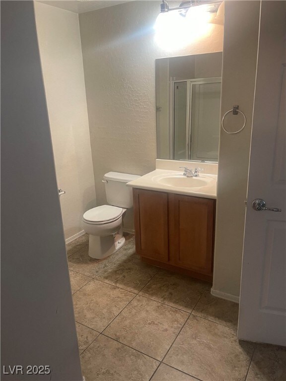 Full bath featuring a stall shower, baseboards, to