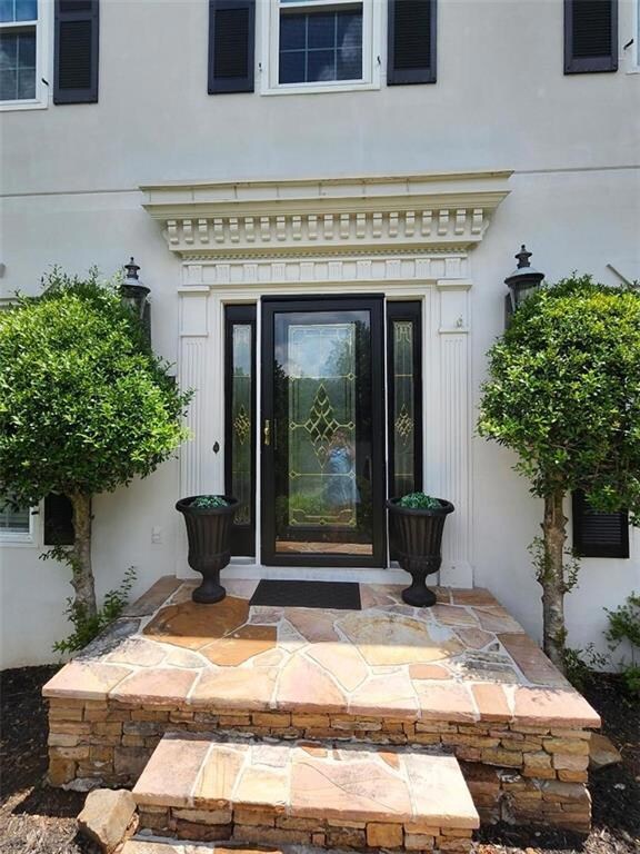 Entrance to property with stucco siding