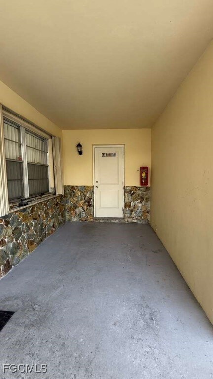 Property entrance with stone siding and stucco siding