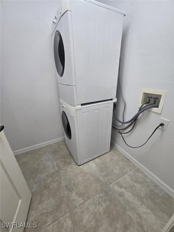 Laundry room with stacked washer / dryer and baseb