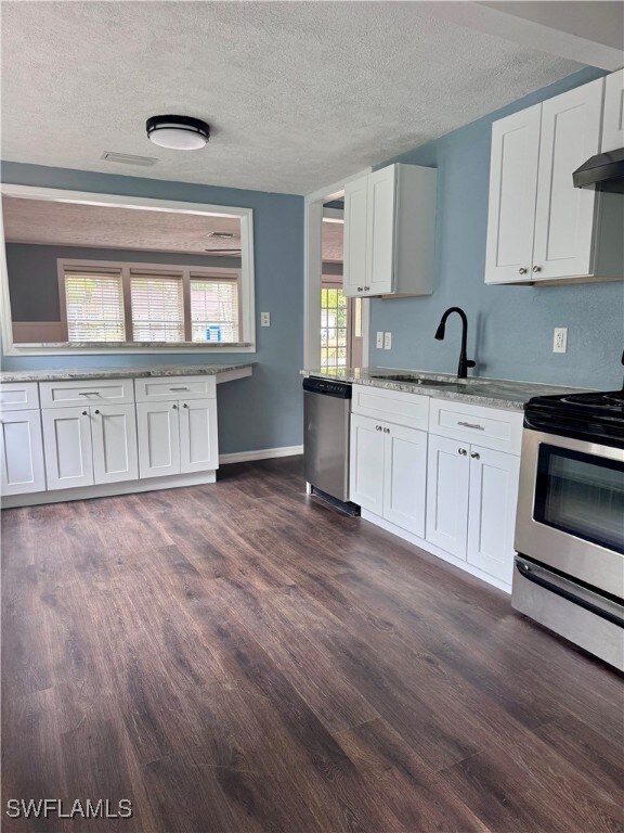 Kitchen featuring stainless steel appliances, dark