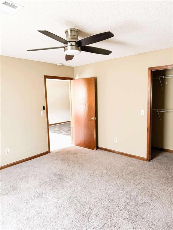 Unfurnished bedroom with carpet floors, a closet, baseboards, a ceiling fan, and a textured ceiling