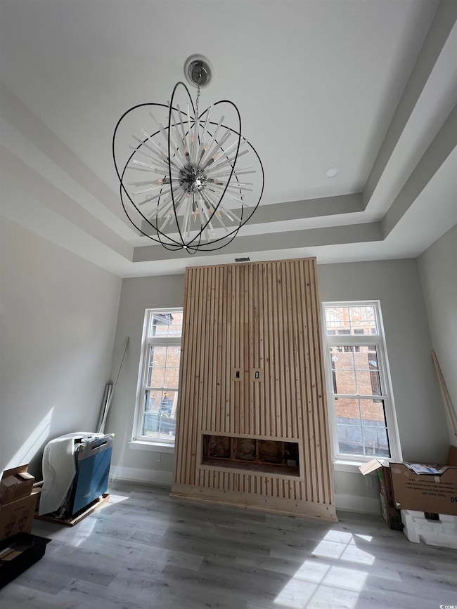 Unfurnished living room featuring baseboards, a ra