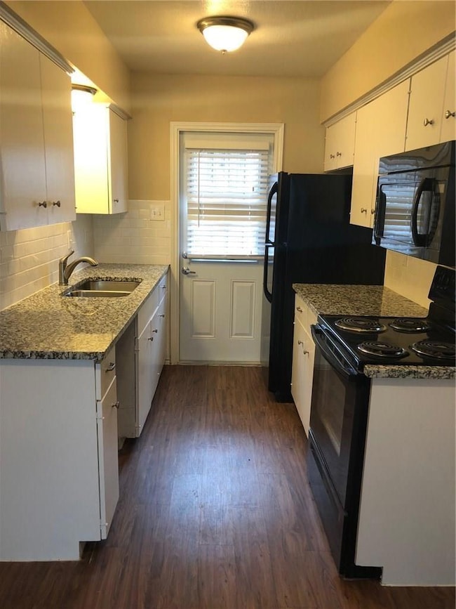 Kitchen featuring dark wood-type flooring, black a