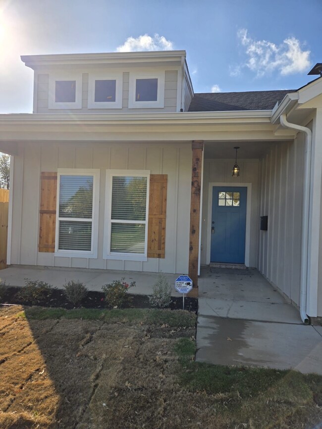 View of exterior entry with board and batten siding, a porch, and a shingled roof