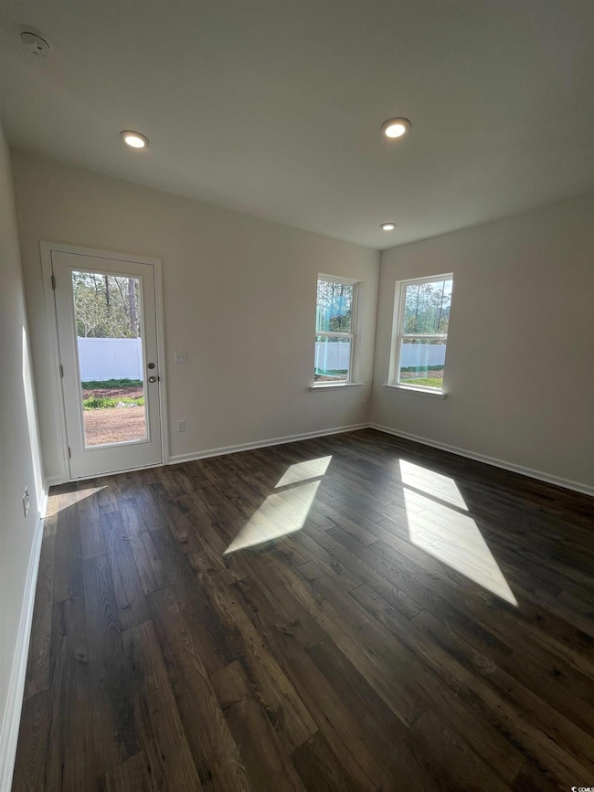 Empty room featuring recessed lighting, dark wood-