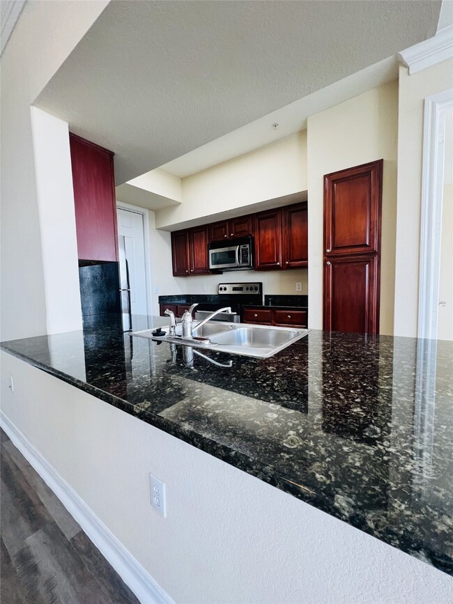 Kitchen includes a breakfast bar, granite counters and stainless appliances