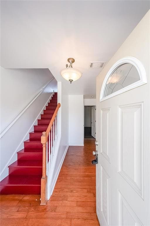Stairs featuring wood finished floors, baseboards,