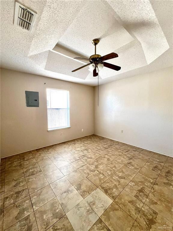 Bedroom with visible vents, a ceiling fan, electric panel, a textured ceiling, and baseboards