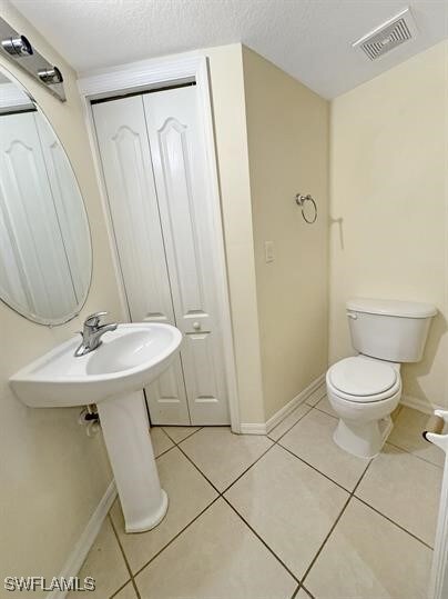 Bathroom featuring tile patterned flooring, toilet
