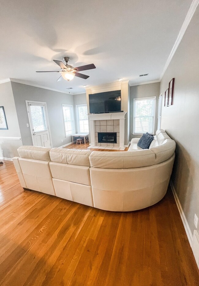 Unfurnished living room featuring a fireplace, hardwood / wood-style floors, a wealth of natural light, and crown molding
