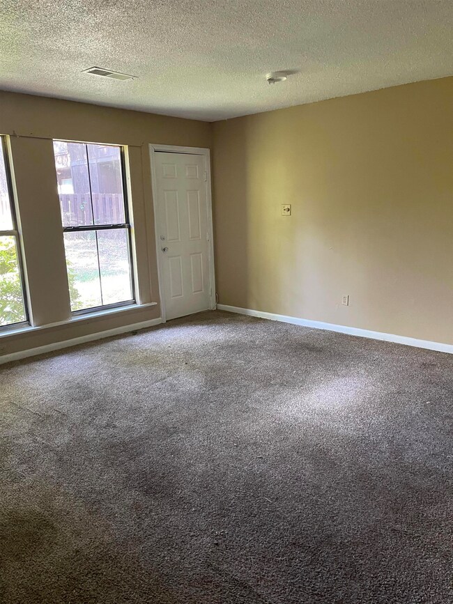 Unfurnished room with a textured ceiling and carpe