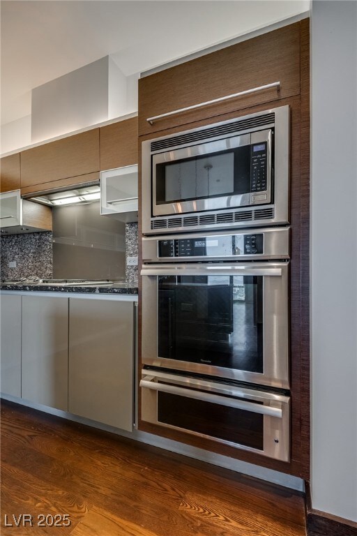 Kitchen with backsplash, dark wood-style flooring,