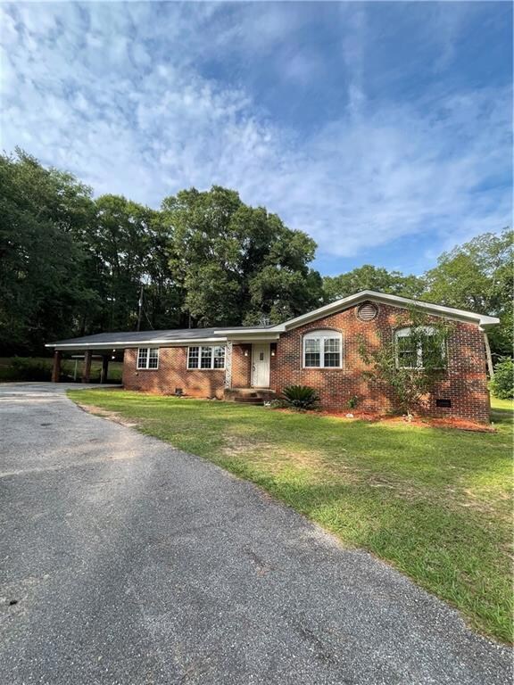 Single story home with brick siding, asphalt driveway, a front yard, and crawl space