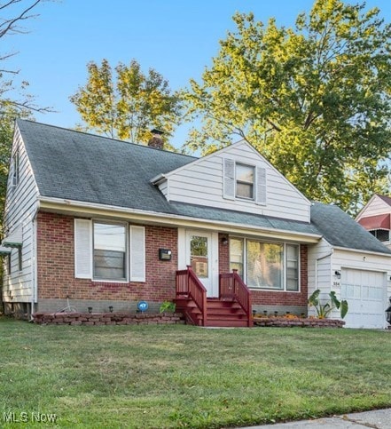 View of front facade with a front lawn, brick siding, an attached garage, roof with shingles, and a chimney