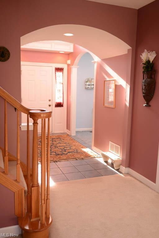 Two story foyer with lots of natural light and cur