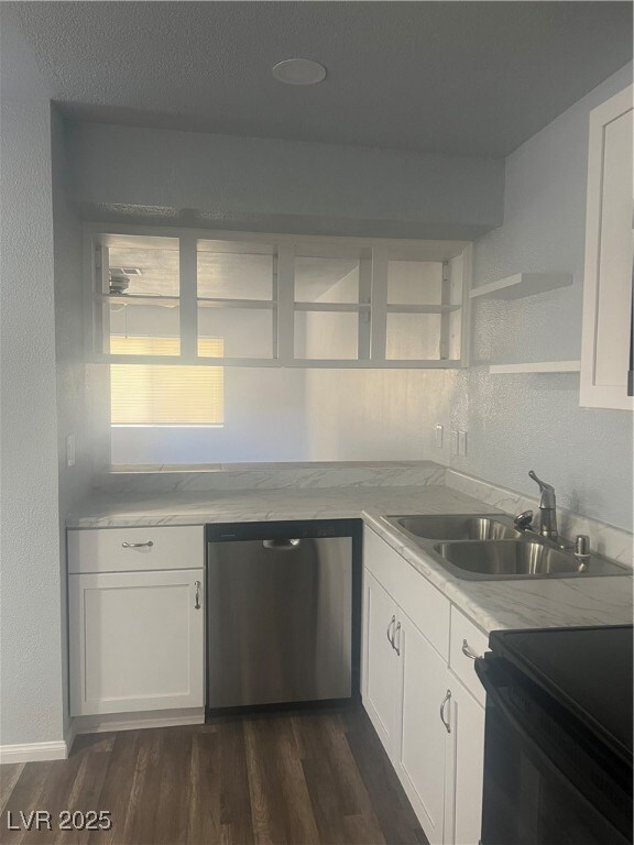 Kitchen with a textured wall, white cabinetry, range, dishwasher, and dark wood finished floors