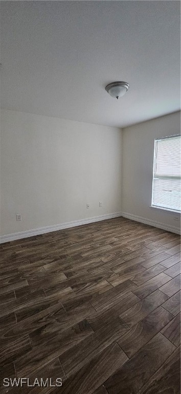 Unfurnished room featuring dark wood-style floors