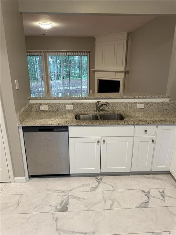 Kitchen featuring stainless steel dishwasher, light marble finish flooring, white cabinetry, and light stone counters
